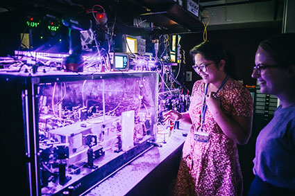 Two female researchers in a photonics laboratory.